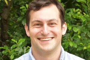 Headshot of Marc Aidinoff in front of leafy tree.